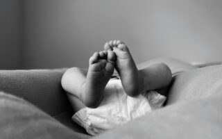 a black and white photo of a baby's feet