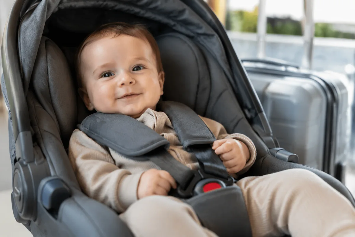Partir à Bali avec un bébé de 4 mois : ce qu'il faut vraiment savoir Gros plan sur un sac à langer ouvert posé sur un lit d'hôtel avec couches crème solaire et thermomètre bébé